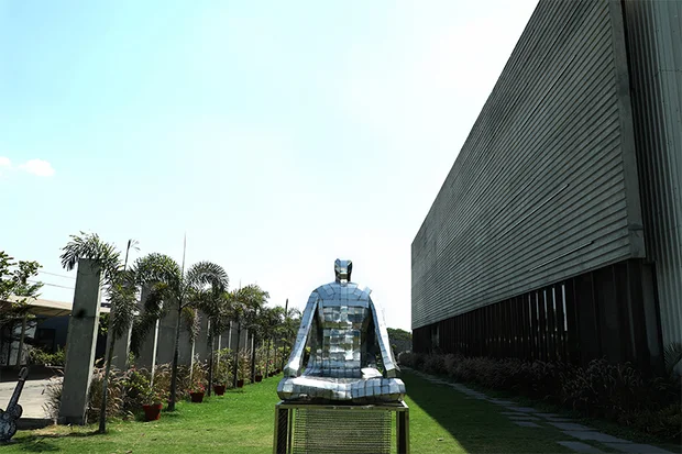 Polished bust on the lawn beside the plant